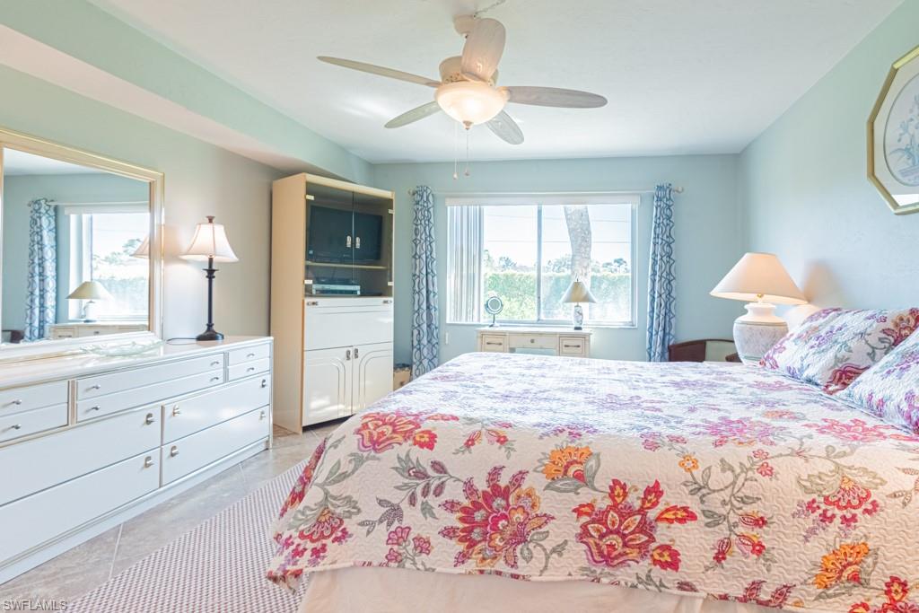 3662 Arctic Circle, Unit 201 Naples, FL 34112 - Photo 17 of 35 a bedroom with a large bed and a chandelier