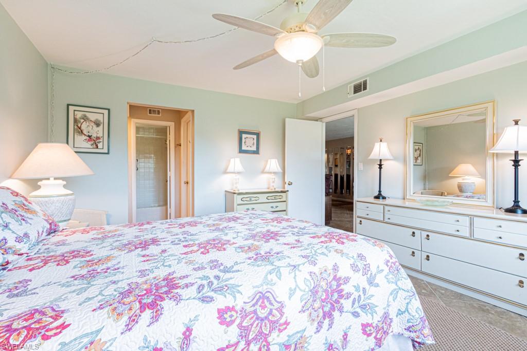 3662 Arctic Circle, Unit 201 Naples, FL 34112 - Photo 19 of 35 a bedroom with a large bed and a chandelier