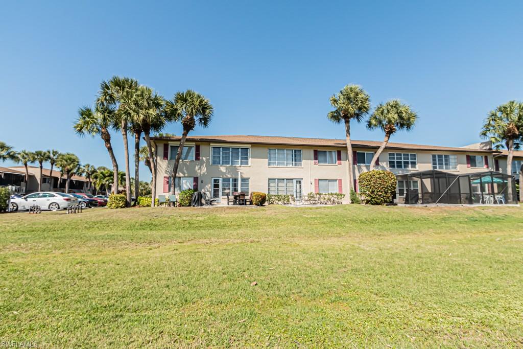 3662 Arctic Circle, Unit 201 Naples, FL 34112 - Photo 31 of 35 a front view of a house with a garden and swimming pool