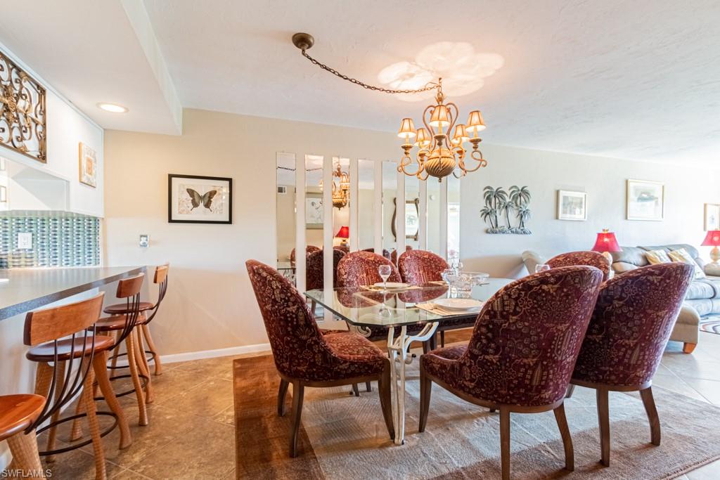 3662 Arctic Circle, Unit 201 Naples, FL 34112 - Photo 9 of 35 a view of a dining room with furniture and chandelier