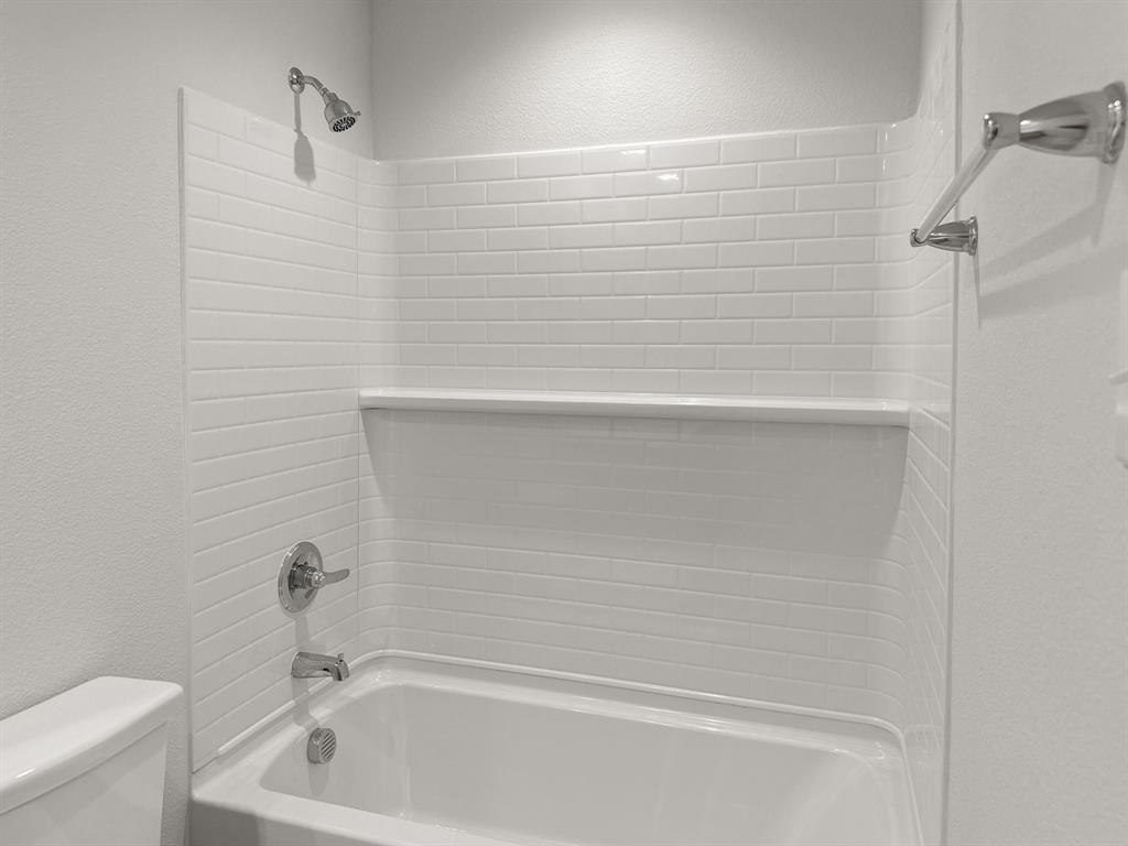 1908 Iris Road Melissa, TX 75454 - Photo 26 of 30 a bathroom with a white bath tub and a shower