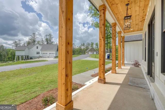 an empty room with wooden floor cabinet and windows