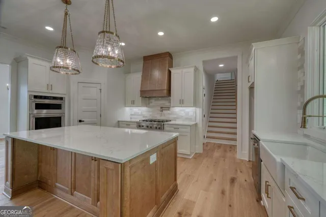 a kitchen with white cabinets and sink