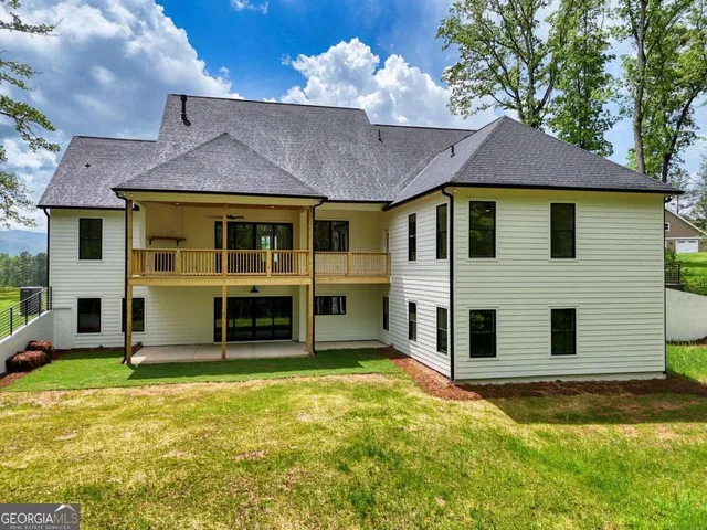 an aerial view of a house with swimming pool and red chairs