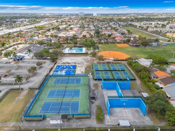 an aerial view of residential houses with outdoor space and swimming pool