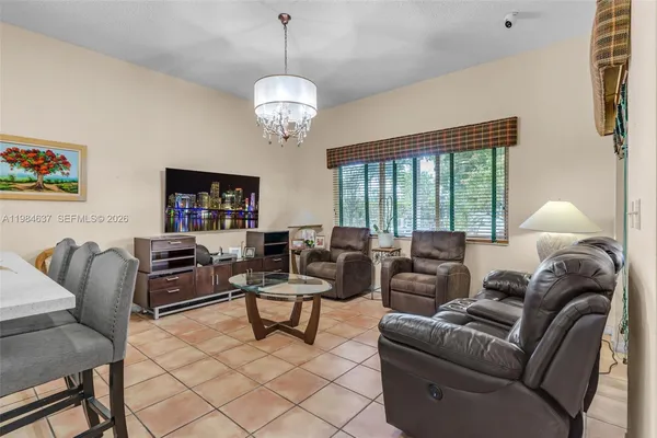 a living room with furniture a dining table and a chandelier