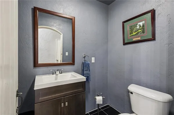 a bathroom with a toilet sink and mirror