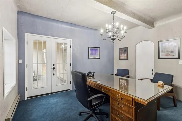 a view of a workspace with furniture and a chandelier