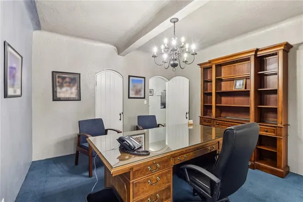 a view of a workspace with furniture and a chandelier