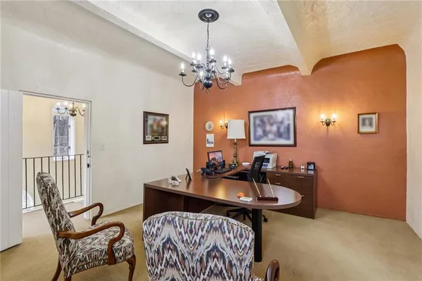 a living room with furniture a chandelier and a window