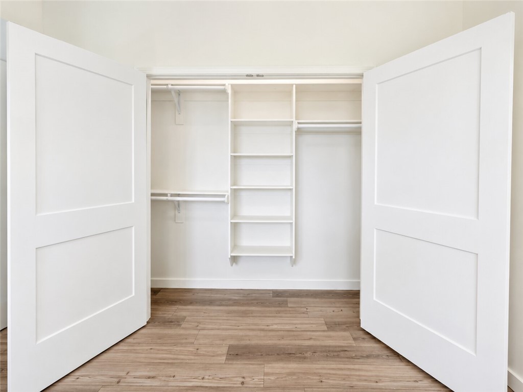 331 Channel Circle Russellville, AR 72802 - Photo 10 of 29 Spacious closet featuring white built-in shelving, dual hanging rods, and wood-finish flooring