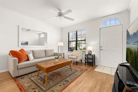 a living room with furniture a flat screen tv and a table