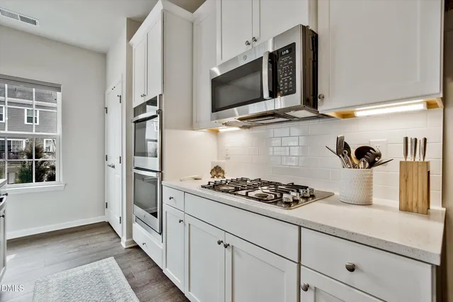 a kitchen with appliances a sink and cabinets