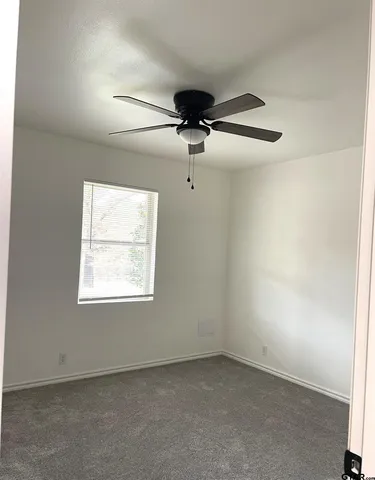 a bathroom with a granite countertop toilet sink and mirror
