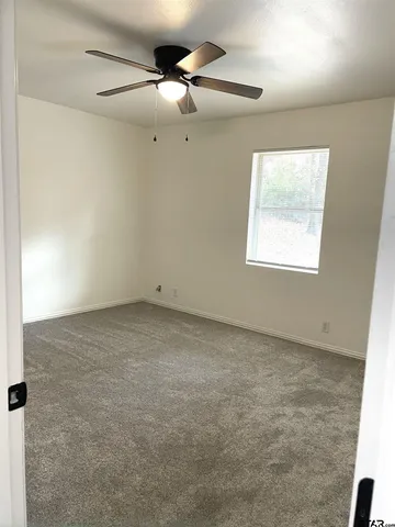 a bathroom with a granite countertop toilet sink and mirror