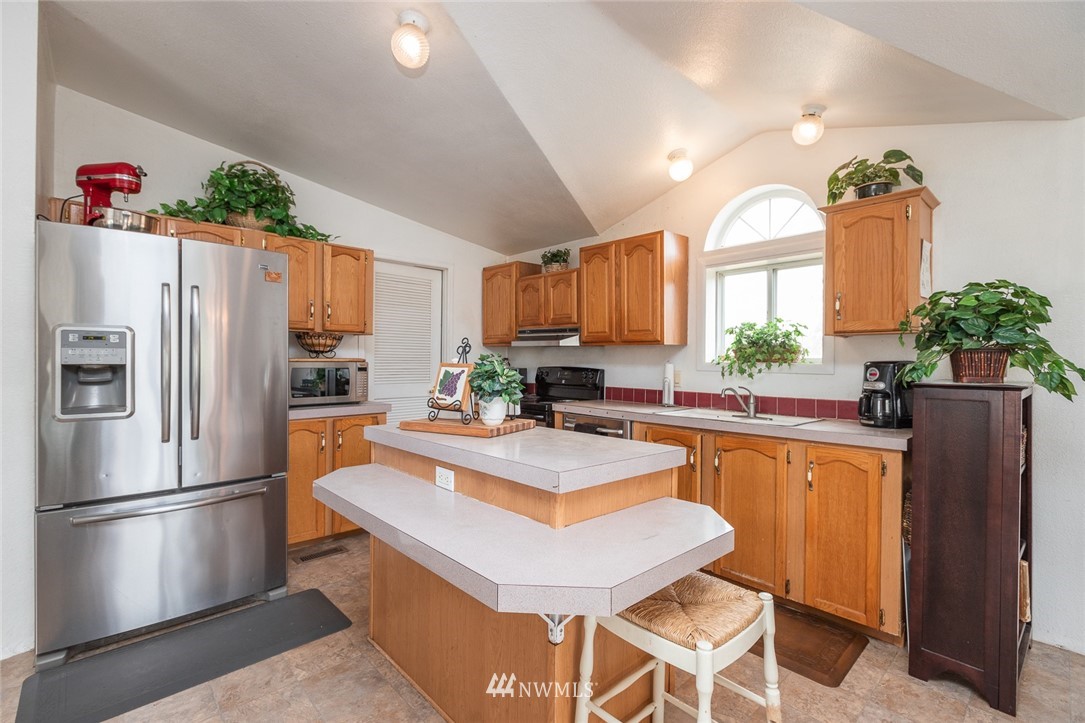 2011 Bishop Road Chehalis, WA 98532 - Photo 6 of 25 a kitchen with granite countertop a refrigerator and a stove top oven
