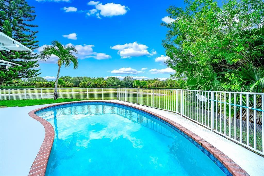 12036 Quilting Lane Boca Raton, FL 33428 - Photo 25 of 25 a view of a swimming pool with a garden and trees