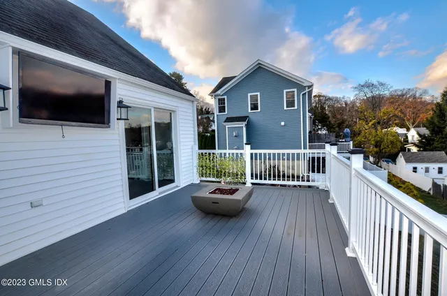 a balcony with wooden floor table and chairs