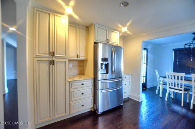 a kitchen with stainless steel appliances granite countertop a refrigerator a sink dishwasher and a stove with wooden floor