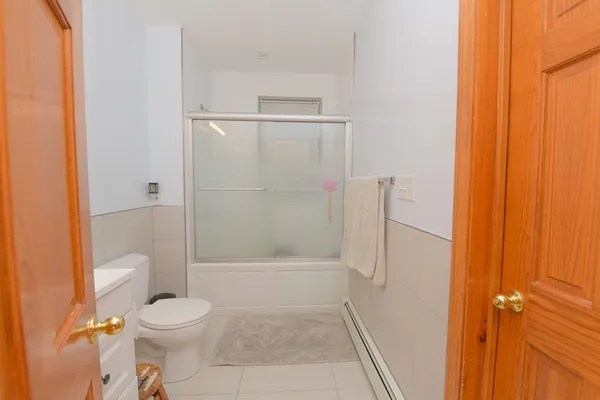 a bathroom with a shower a toilet and a window