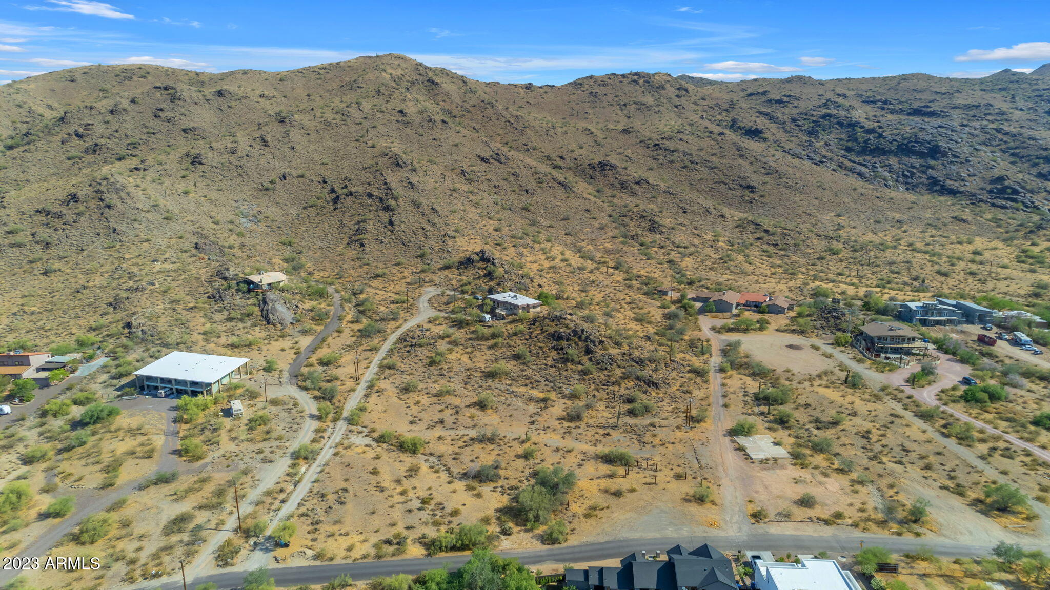 a view of a dry yard with mountains in the background