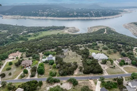 an aerial view of residential houses with outdoor space and lake