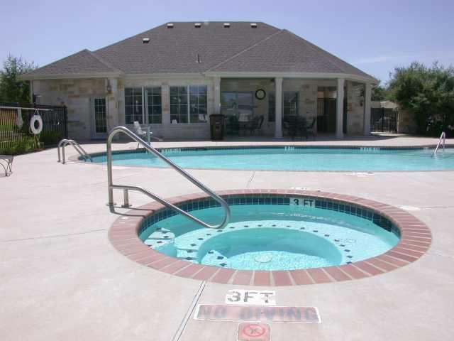 1900 Scofield Ridge Parkway, Unit 4701 Austin, TX 78727 - Photo 25 of 27 A sparkling community pool and spa await with a stone-clad clubhouse for leisurely enjoyment.