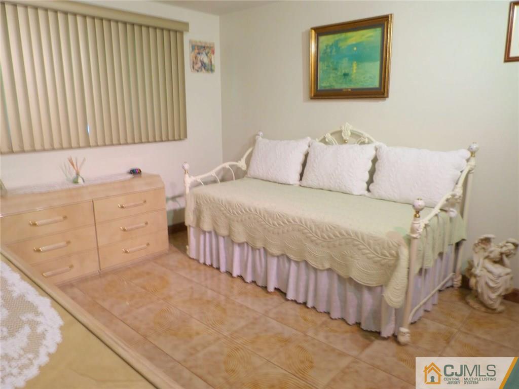 7 Gramercy Road Old Bridge, NJ 08857 - Photo 19 of 24 a bedroom with a bed and a lamp on dresser