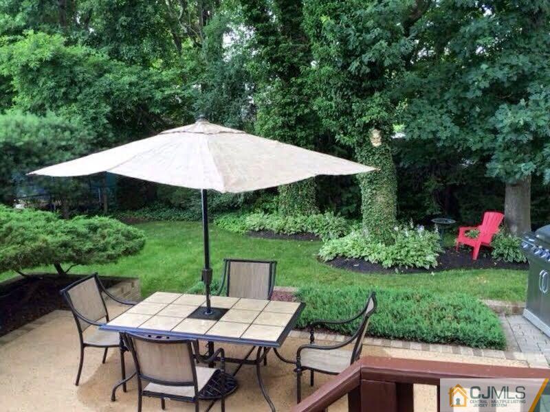 7 Gramercy Road Old Bridge, NJ 08857 - Photo 23 of 24 a view of a wooden table and chairs under an umbrella