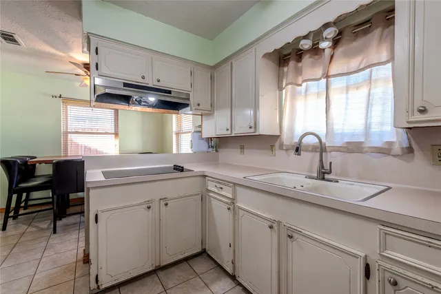 a kitchen with cabinets appliances a sink and a window