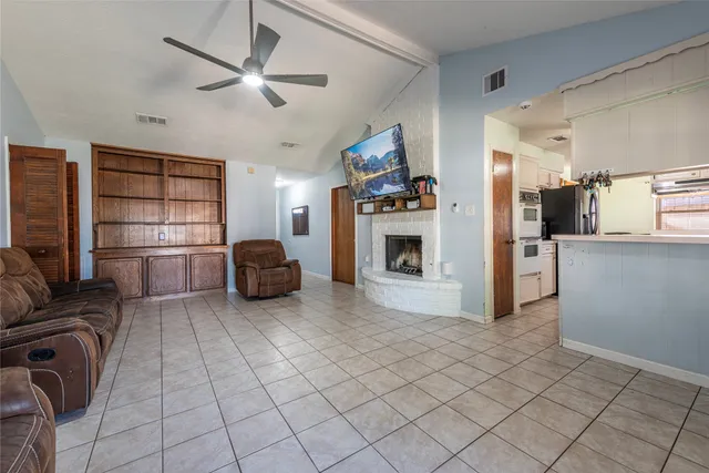 a living room with furniture a ceiling fan and a window