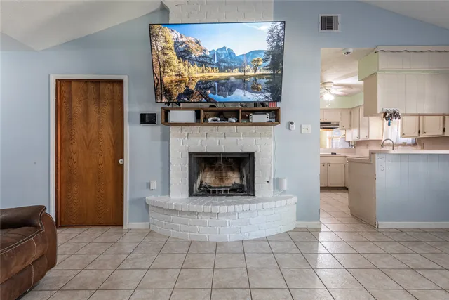 a living room with furniture a flat screen tv and a fireplace