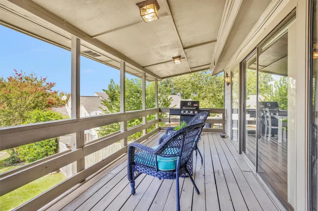 a view of a porch with furniture and wooden floor