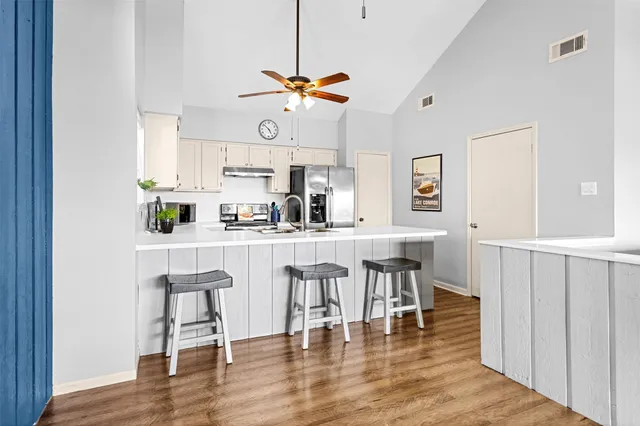 a kitchen with a dining table chairs and white cabinets
