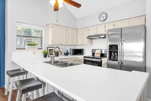 a kitchen with kitchen island a stove a sink and a refrigerator