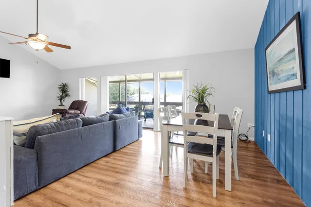 a living room with furniture a dining table and a large window
