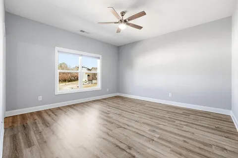 an empty room with window and wooden floor
