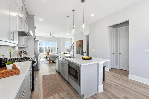 a kitchen with a stove a refrigerator a sink dishwasher with a dining table and chairs
