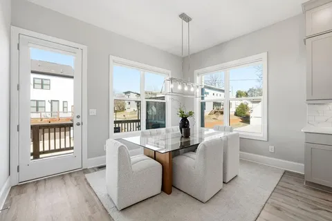 a view of a dining room with furniture large windows and wooden floor