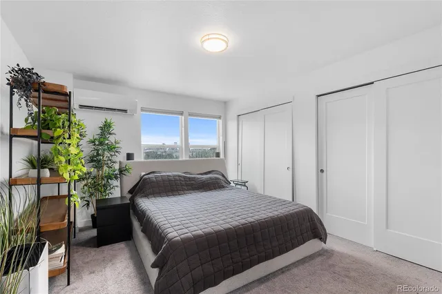 a bedroom with a large bed and a potted plant