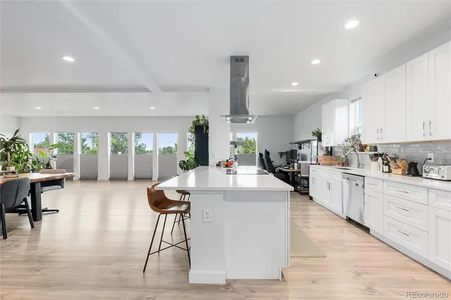 a kitchen with stainless steel appliances kitchen island granite countertop a stove a sink a refrigerator and cabinets