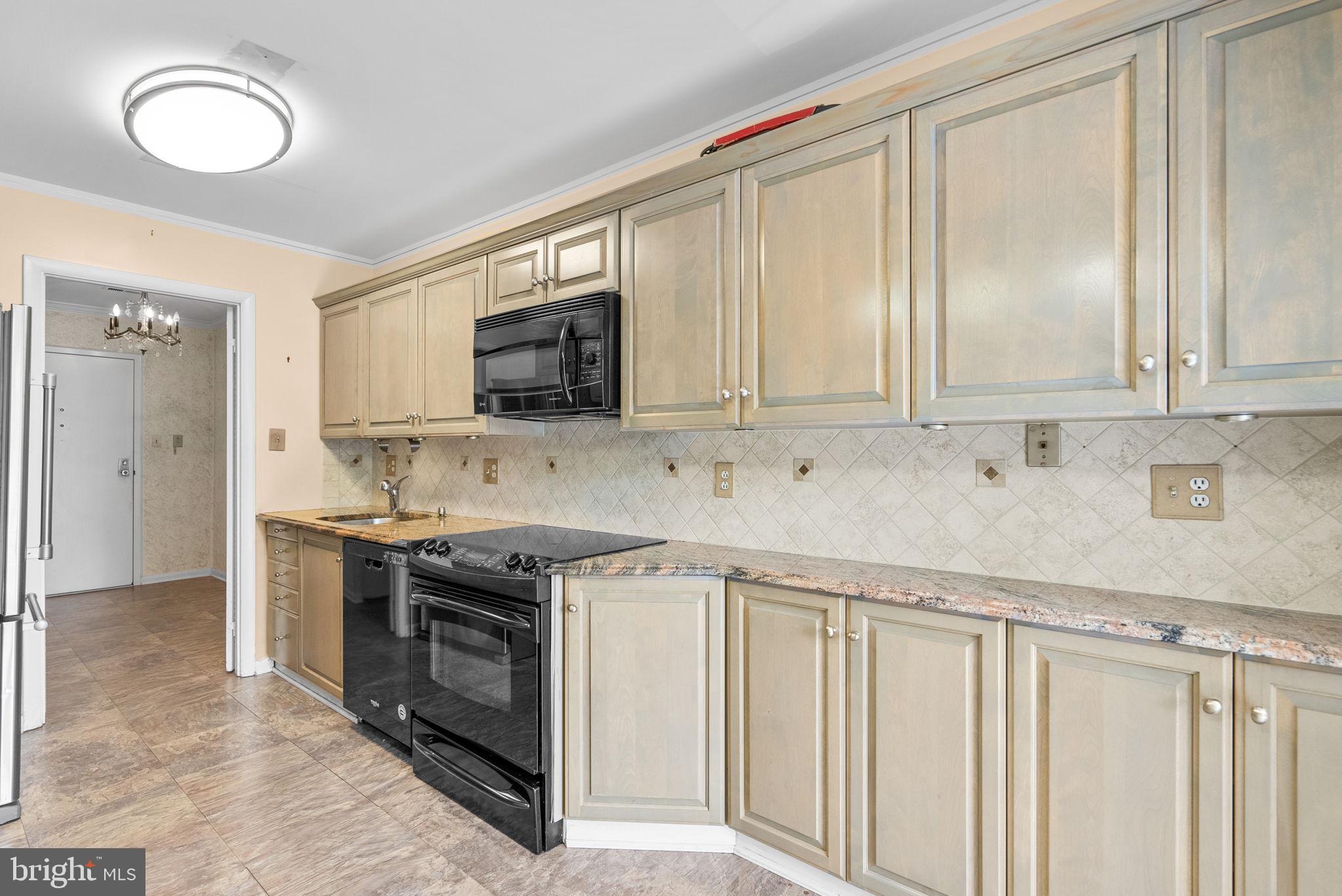6300 Red Cedar Place, Unit 310 Baltimore, MD 21209 - Photo 12 of 28 a kitchen with stainless steel appliances granite countertop a stove and a sink
