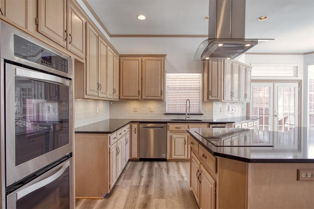4564 Hitching Post Lane Plano, TX 75024 - Photo 12 of 40 a kitchen with stainless steel appliances granite countertop a sink a stove and cabinets