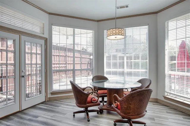 a dining room with furniture large windows and wooden floor