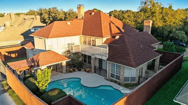 an aerial view of a house with balcony and trees