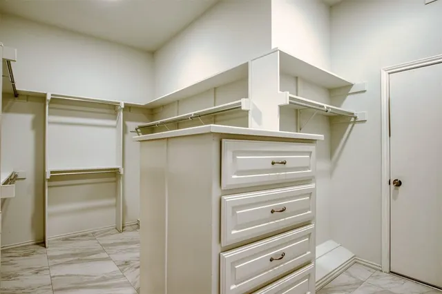 a view of walk in closet with empty racks