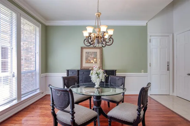 a view of a dining room with furniture a chandelier and wooden floor