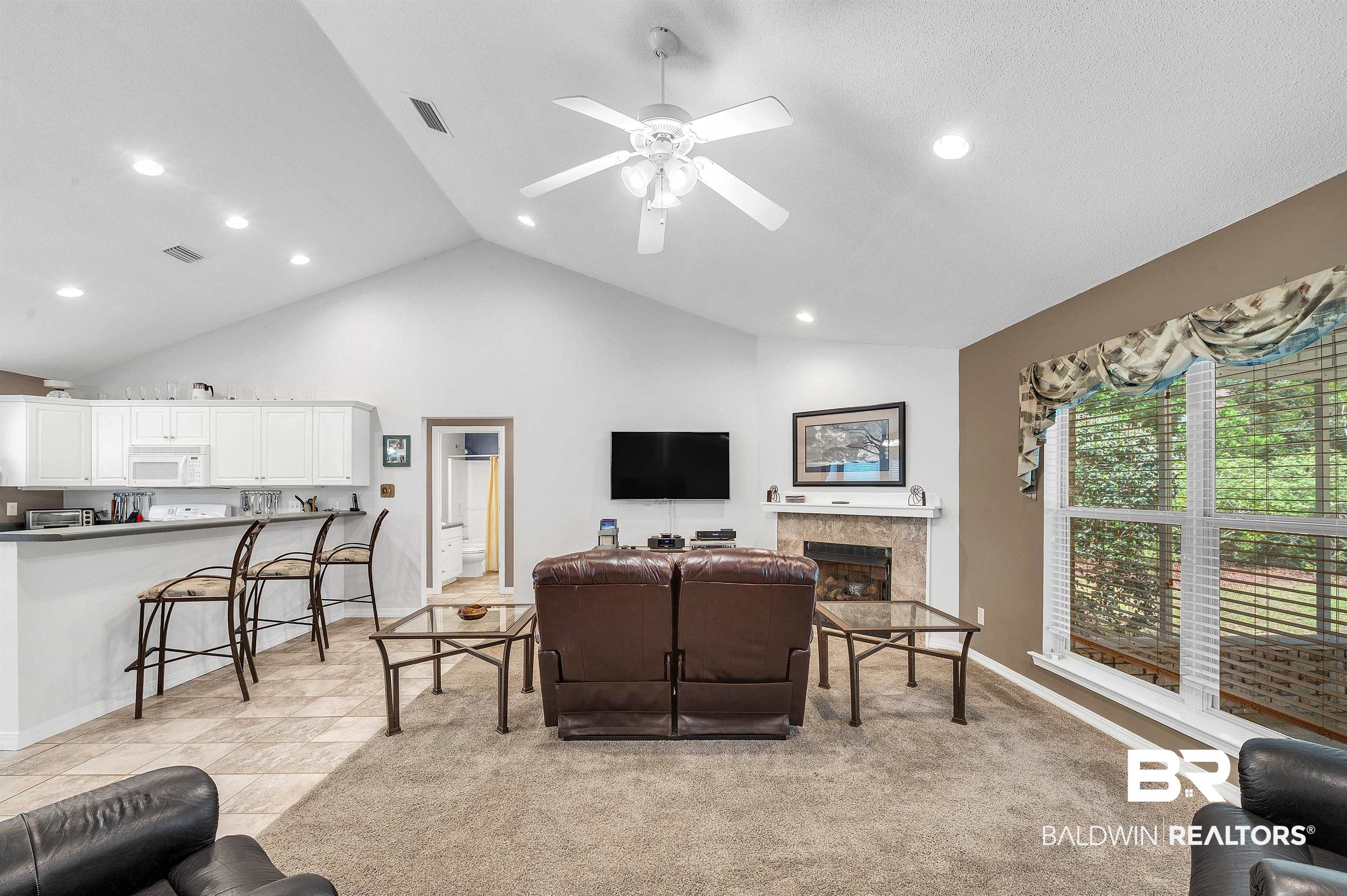 9908 Clarke Ridge Road Foley, AL 36535 - Photo 27 of 56 Living room featuring high vaulted ceiling, baseboards, visible vents, a ceiling fan, and a fireplace