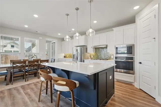 a kitchen with kitchen island a dining table and chairs
