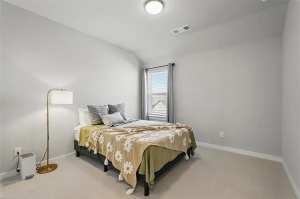 a bed sitting in a bedroom next to a window